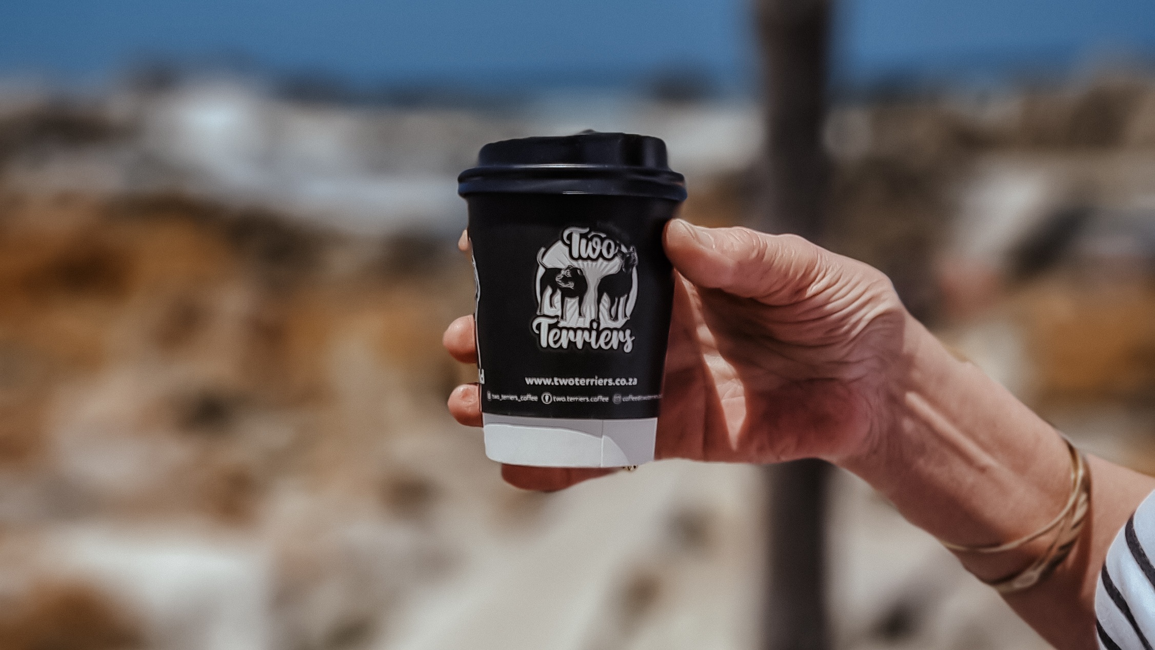 Branded cup at rocks of old harbour in Betty's Bay, Cape Town
